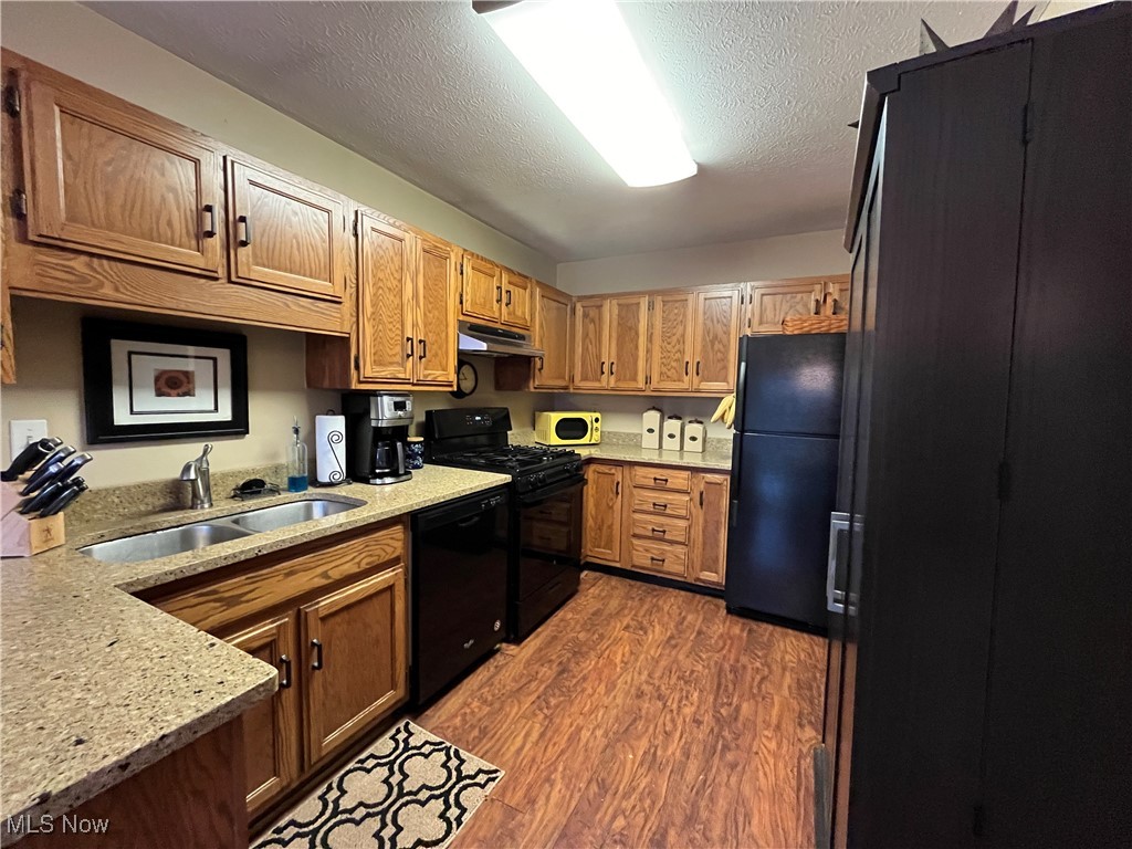 4015 Marks Road, Unit 4B Medina, OH 44256 - Photo 12 of 39 Kitchen with dark hardwood / wood-style flooring, light stone counters, a textured ceiling, sink, and black appliances