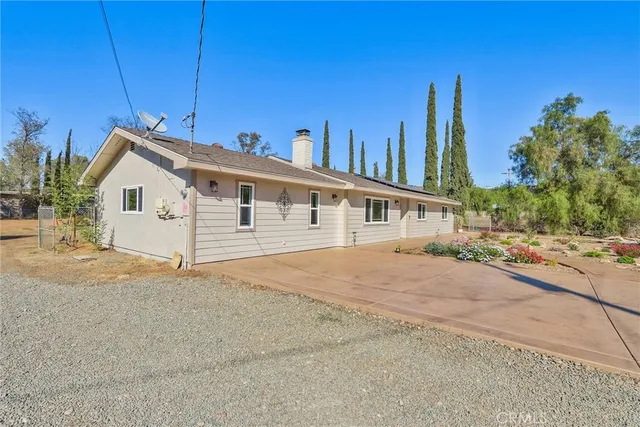 a view of house with a yard and potted plants