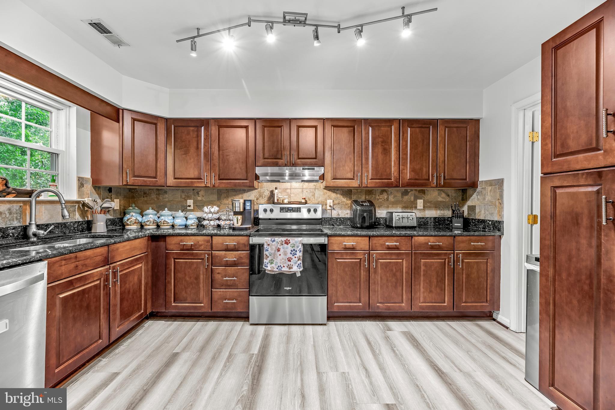8328 Ridge View Road Lusby, MD 20657 - Photo 11 of 34 a kitchen with stainless steel appliances granite countertop wooden cabinets a stove a sink and a refrigerator