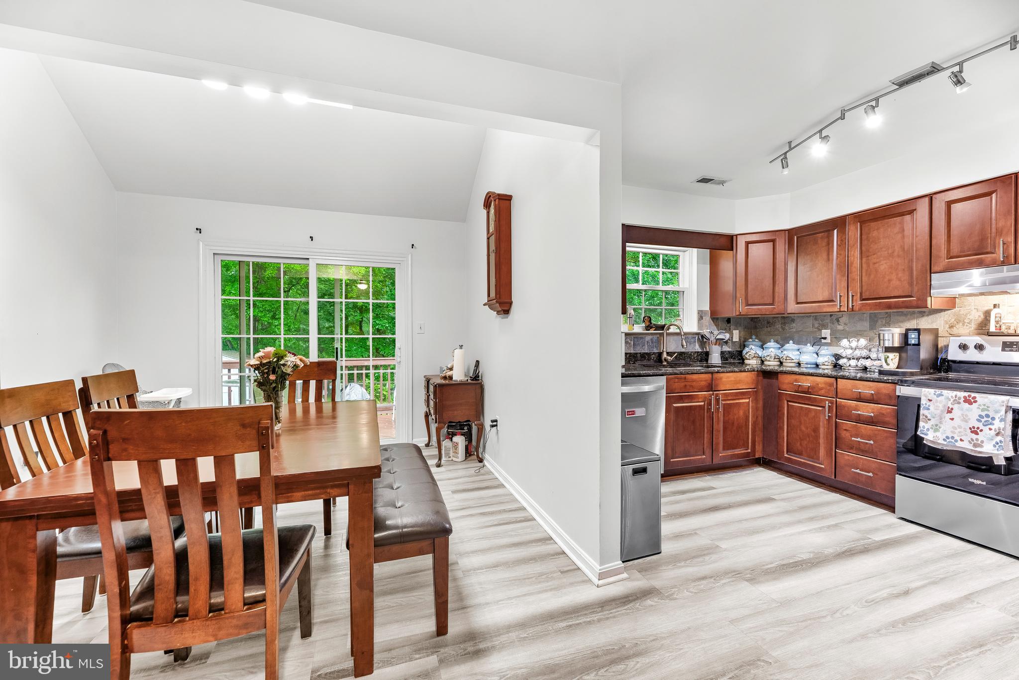 8328 Ridge View Road Lusby, MD 20657 - Photo 6 of 34 a kitchen with stainless steel appliances granite countertop a refrigerator a stove a sink dishwasher and a dining table with wooden floor