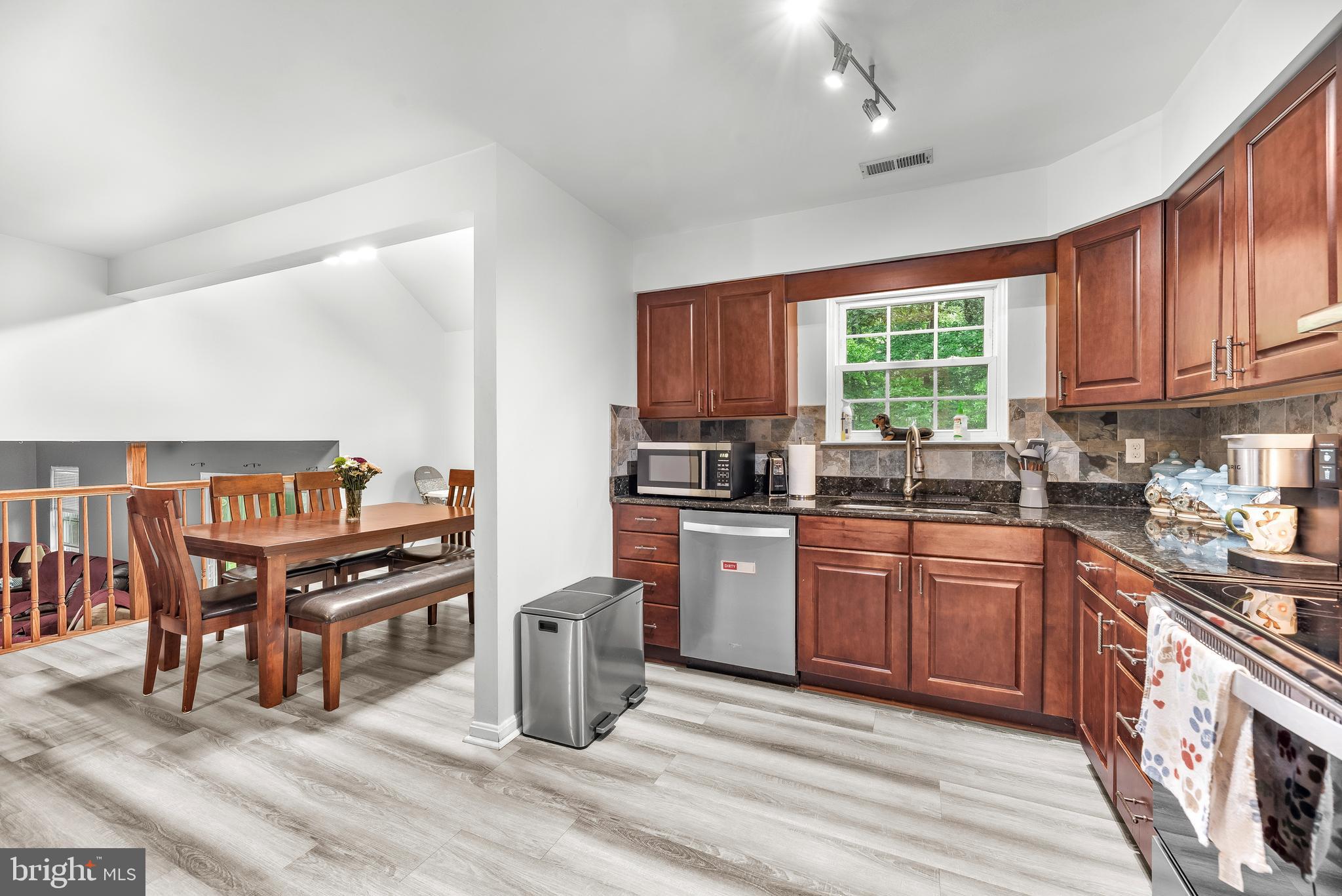 8328 Ridge View Road Lusby, MD 20657 - Photo 9 of 34 a kitchen with stainless steel appliances granite countertop a stove top oven a sink dishwasher and cabinets with wooden floor