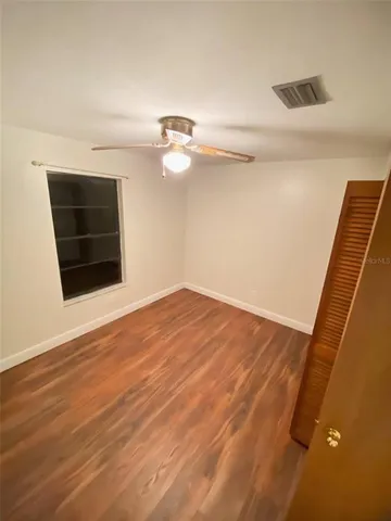 an empty room with wooden floor and closet