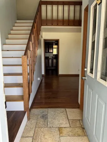 a view of a hallway with wooden floor and staircase