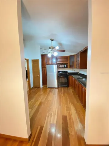 a view of a kitchen with refrigerator sink and wooden floor