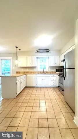 a kitchen with granite countertop cabinets a table and chairs in it