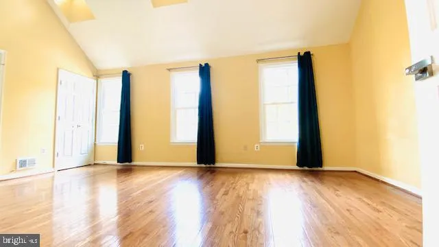 a view of a hallway with entryway wooden floor and front door