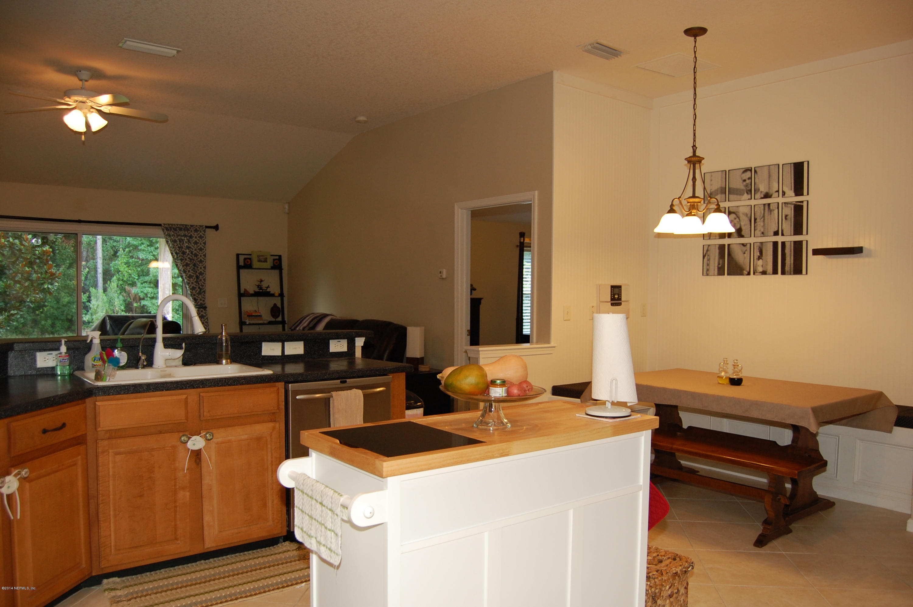 404 Spring Ridge Court St. Augustine, FL 32092 - Photo 11 of 31 a dining hall with couches a flat tv screen and a dining table with garden view
