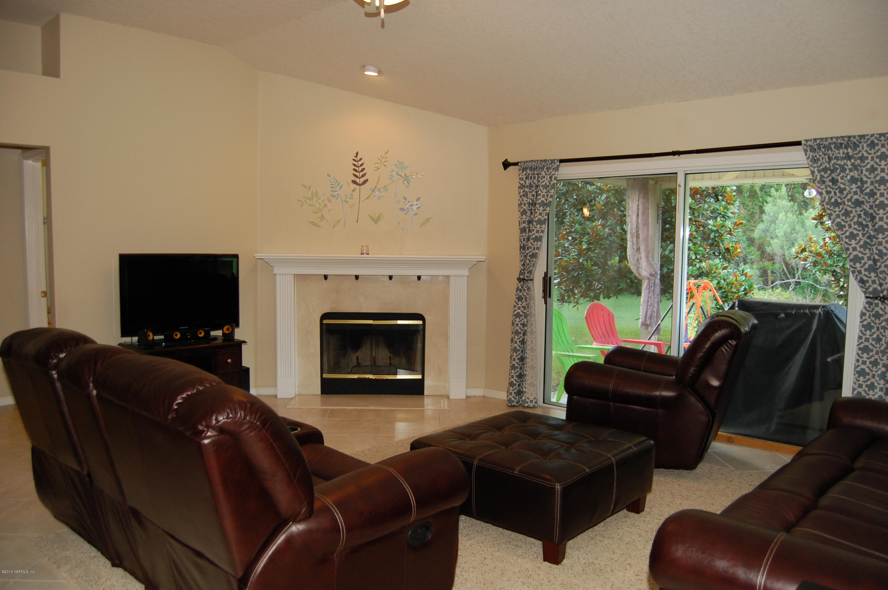 404 Spring Ridge Court St. Augustine, FL 32092 - Photo 13 of 31 a living room with furniture a fireplace and a flat screen tv