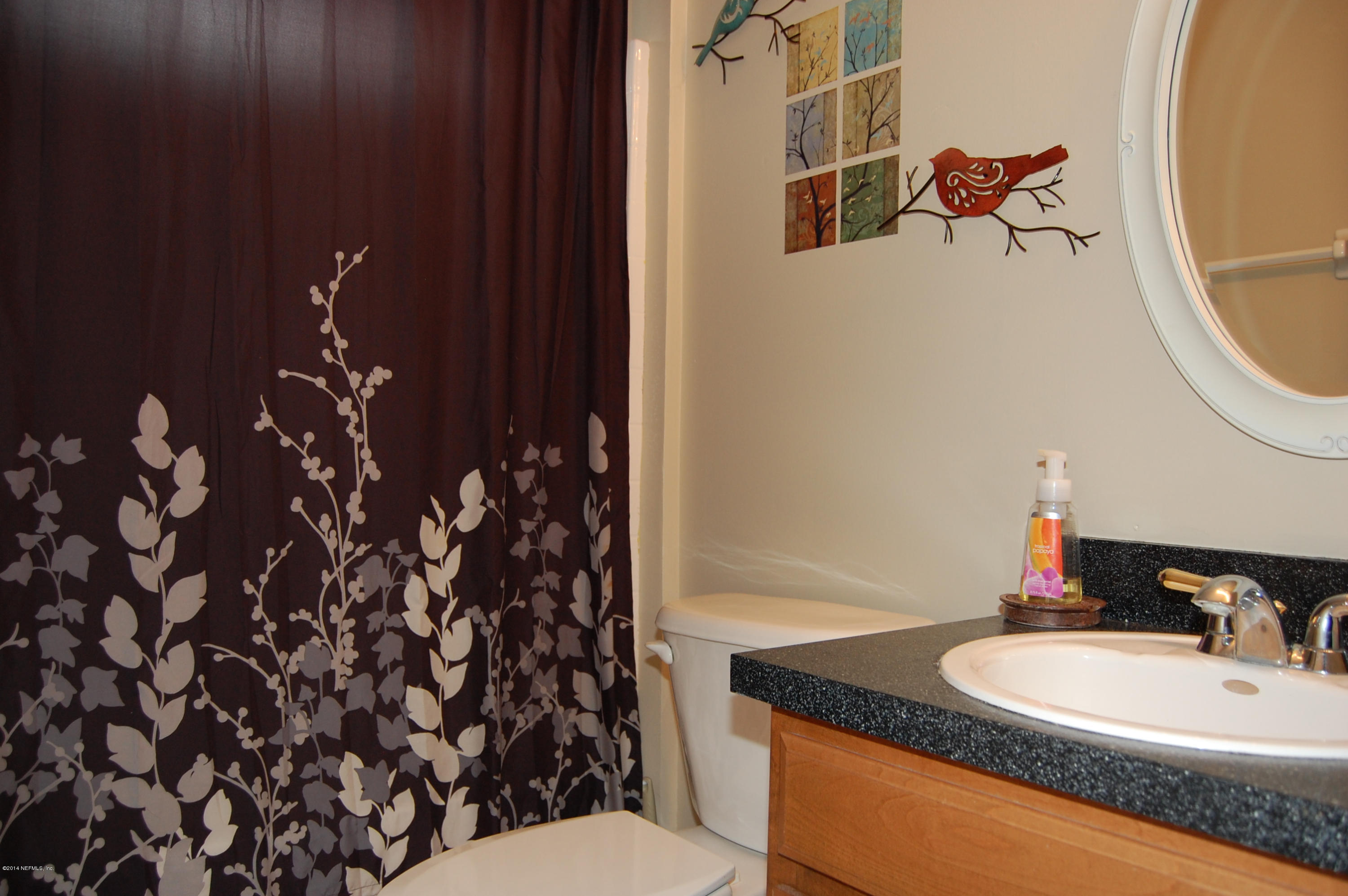 404 Spring Ridge Court St. Augustine, FL 32092 - Photo 18 of 31 a bathroom with a granite countertop sink a toilet and mirror