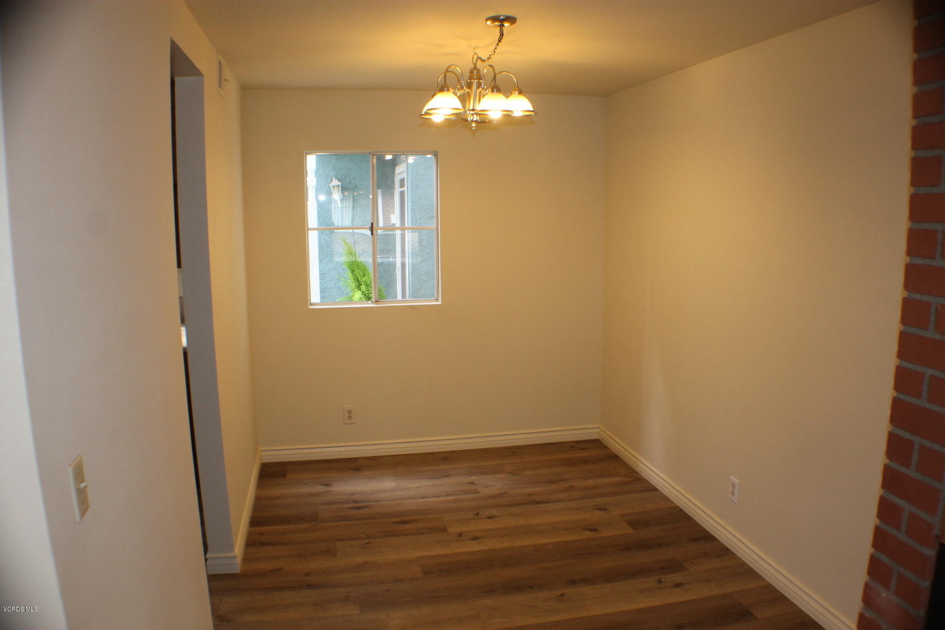 1878 Rory Lane, Unit 2 Simi Valley, CA 93063 - Photo 6 of 30 a view of a hallway with wooden floor and a chandelier