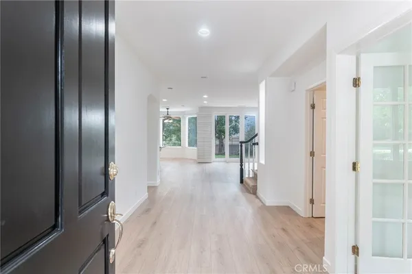 a view of a hallway with wooden floor and glass door