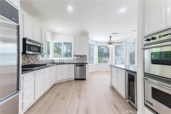 a large kitchen with a large window a sink and stainless steel appliances