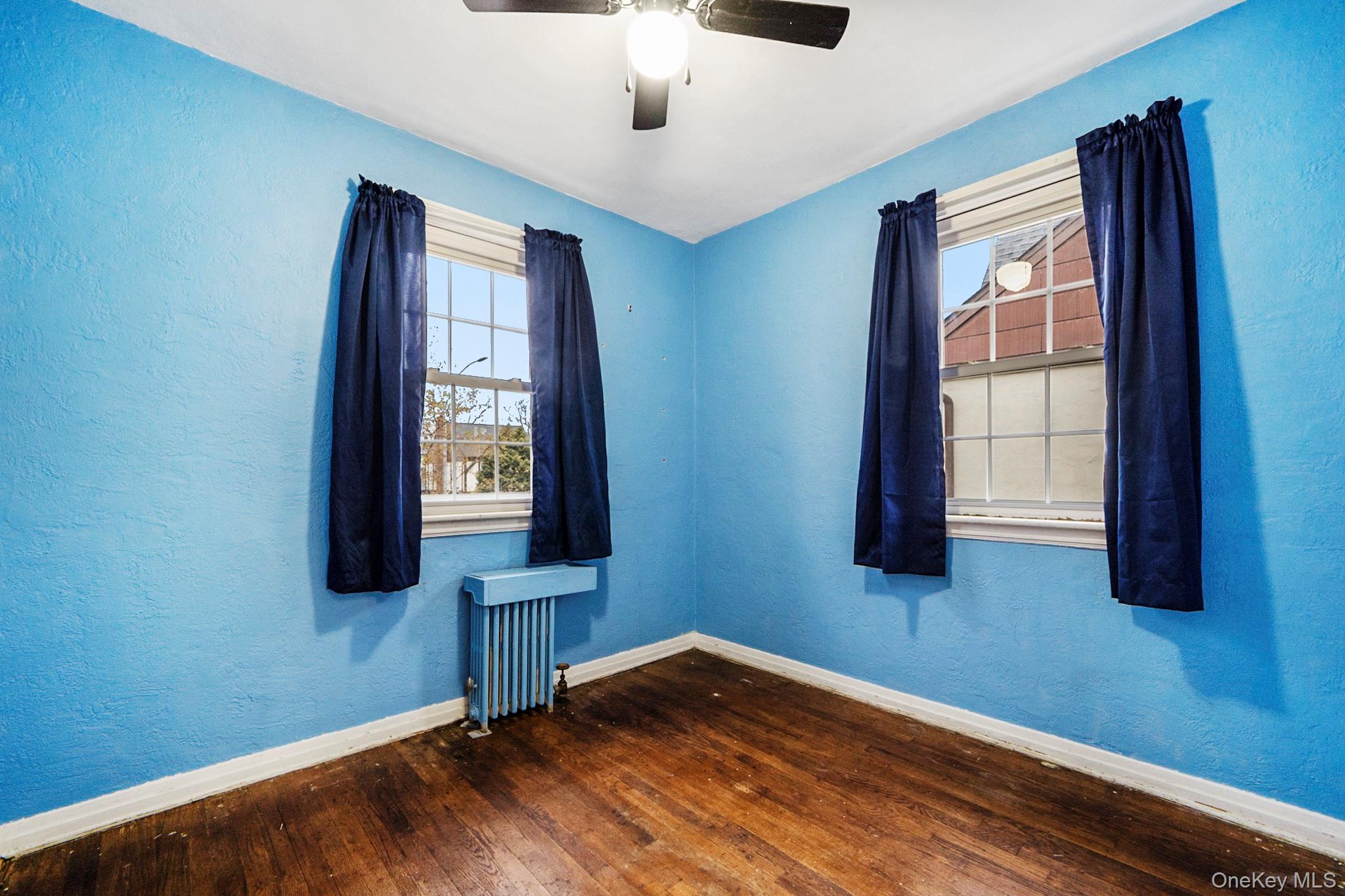 86-33 253rd Street Queens, NY 11426 - Photo 7 of 17 a view of an empty room with wooden floor and a window