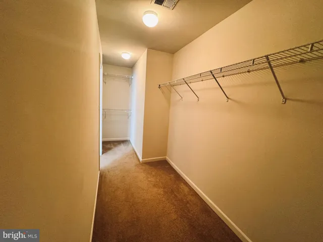 an empty room with chandelier fan and windows