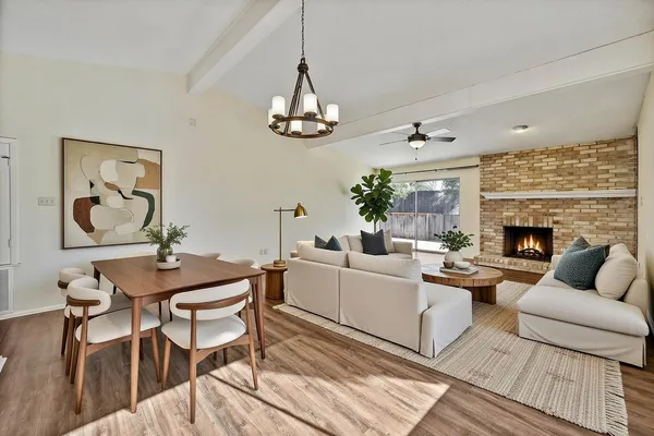 a living room with furniture a chandelier and a fireplace