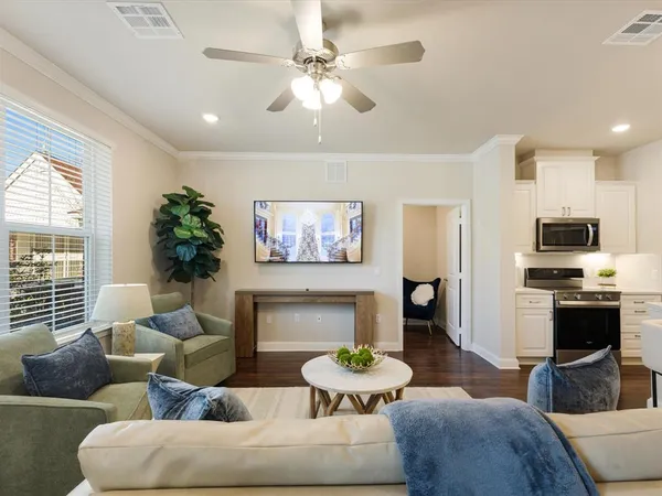 a kitchen with stainless steel appliances kitchen island granite countertop a sink a stove a refrigerator and island with wooden floor