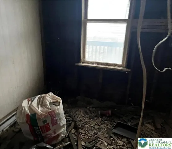 a room with a chair and potted plant next to a window