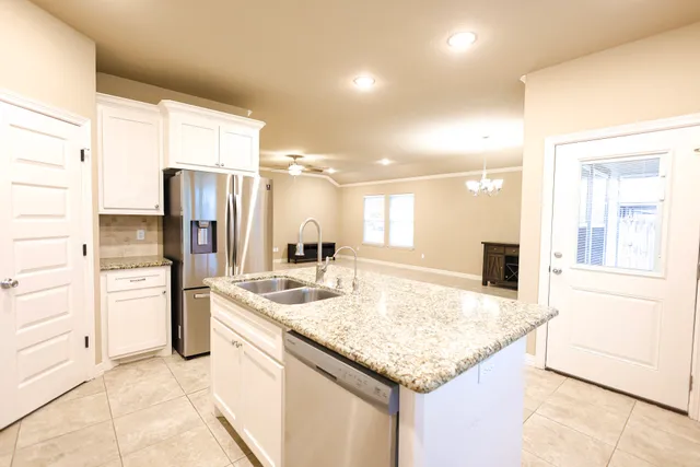 a kitchen with granite countertop a sink and a large window