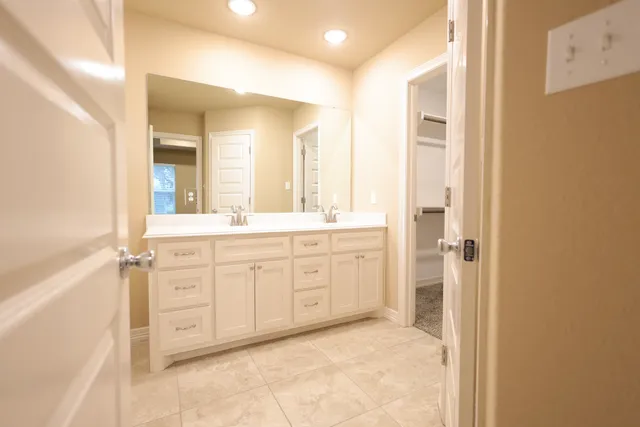 a bathroom with a tub sink shower and two mirror