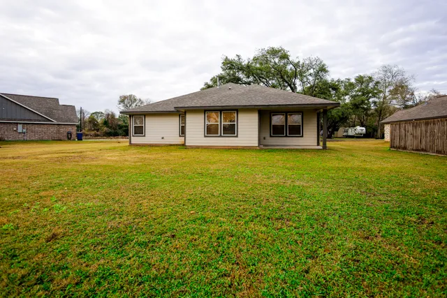 a front view of a house with yard and trees