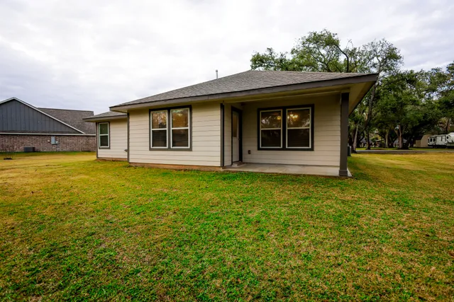 a front view of a house with a yard and trees