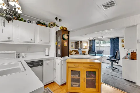 a view of a kitchen with cabinets and wooden floor