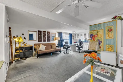 a view of a workspace with furniture and a window