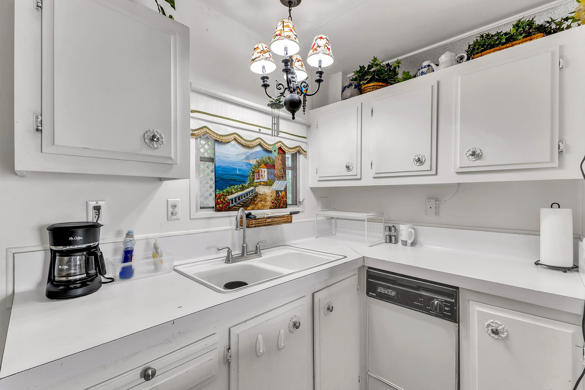 219 Stone Terrace Palm Springs, CA 92264 - Photo 10 of 41 a kitchen with a sink dishwasher and white cabinets