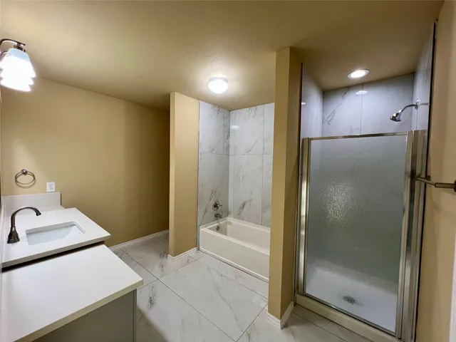 a bathroom with a tub sink and shower