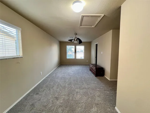 an empty room with windows and ceiling fan