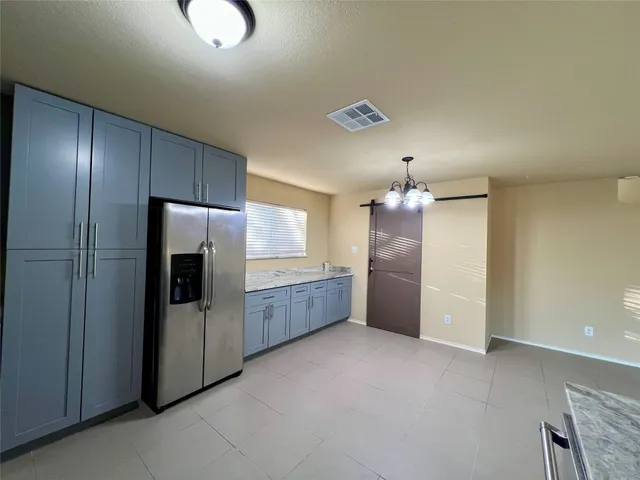 a kitchen with granite countertop a refrigerator and a sink