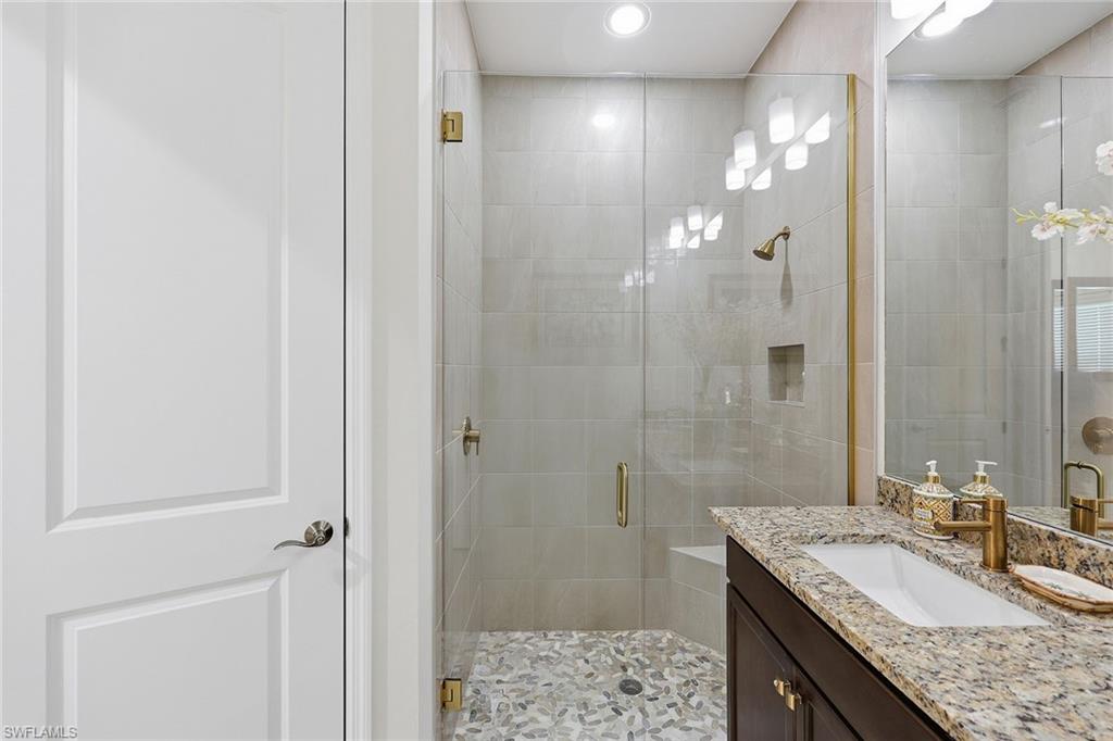 7204 Cayo Coco Lane Naples, FL 34113 - Photo 17 of 22 a bathroom with a granite countertop sink a shower and a mirror