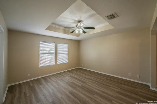 an empty room with a window and a ceiling fan