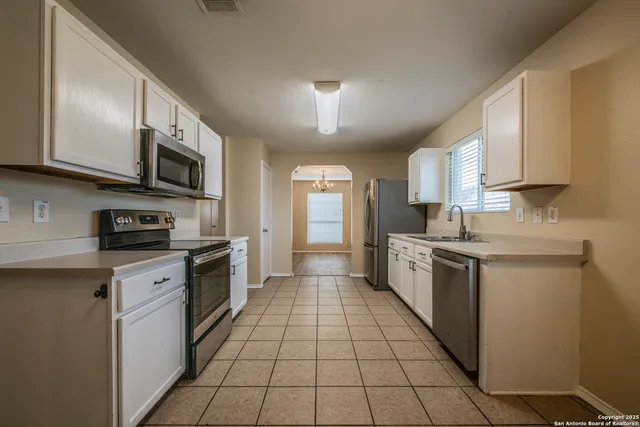 a large kitchen with stainless steel appliances granite countertop a stove sink and cabinets