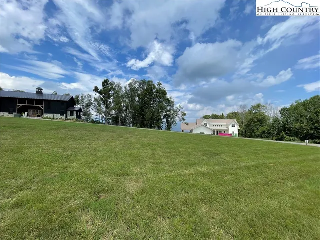 a view of a green field with wooden fence