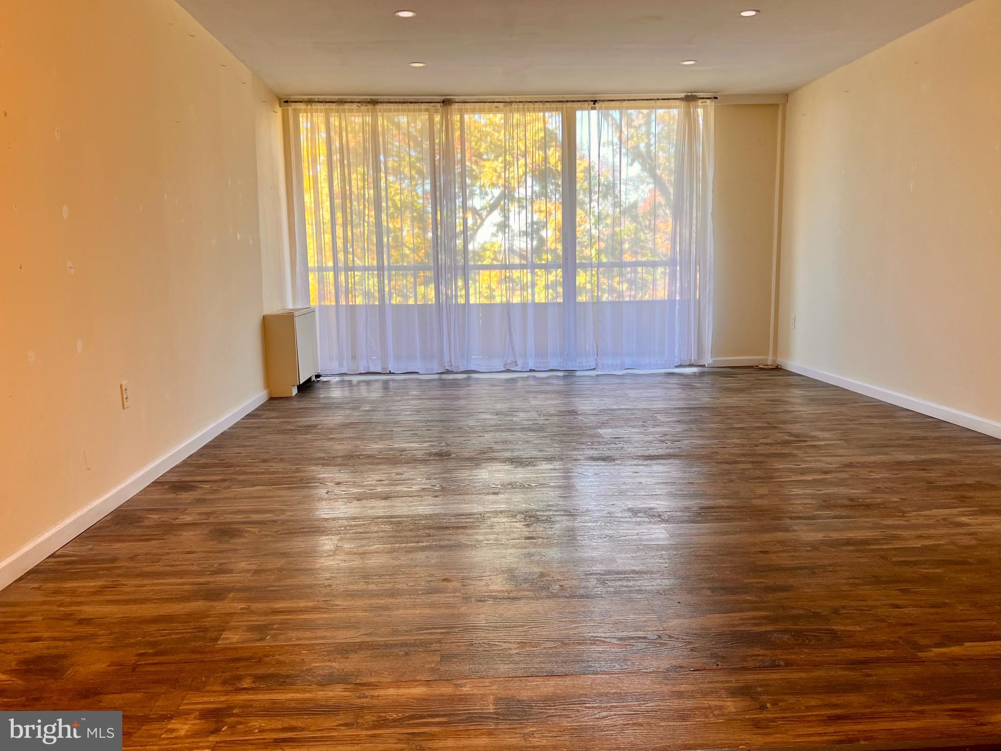 100 West Avenue, Unit 418S Jenkintown, PA 19046 - Photo 7 of 18 a view of an empty room with wooden floor and a window