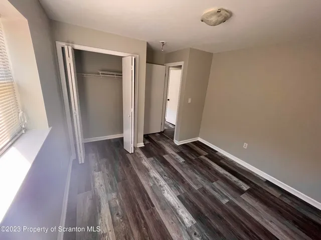 a view of a room with wooden floor