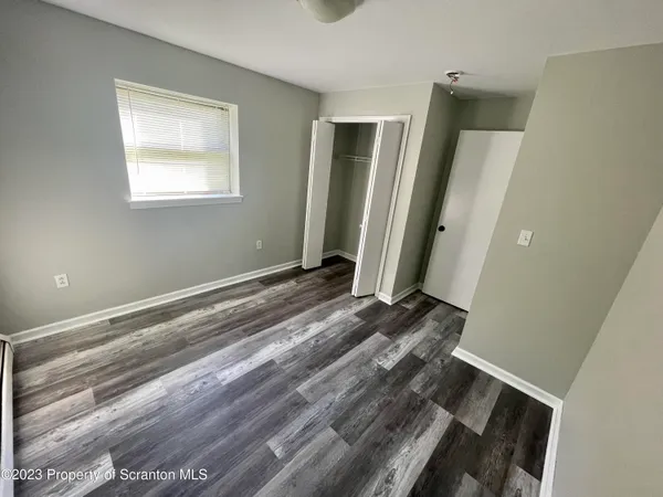 a view of a livingroom with wooden floor and a window