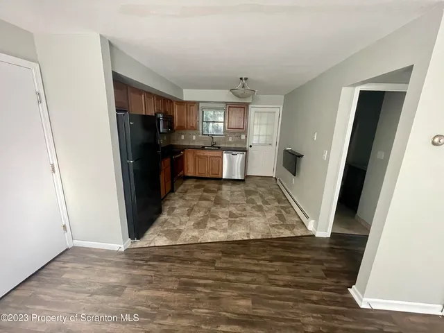a view of kitchen with refrigerator microwave and stove