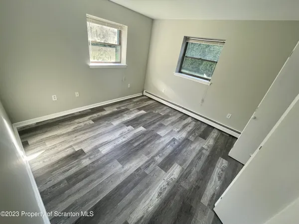 a view of a room with wooden floor and window