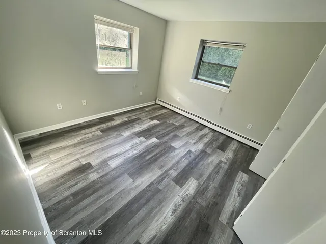 a view of a room with wooden floor and window
