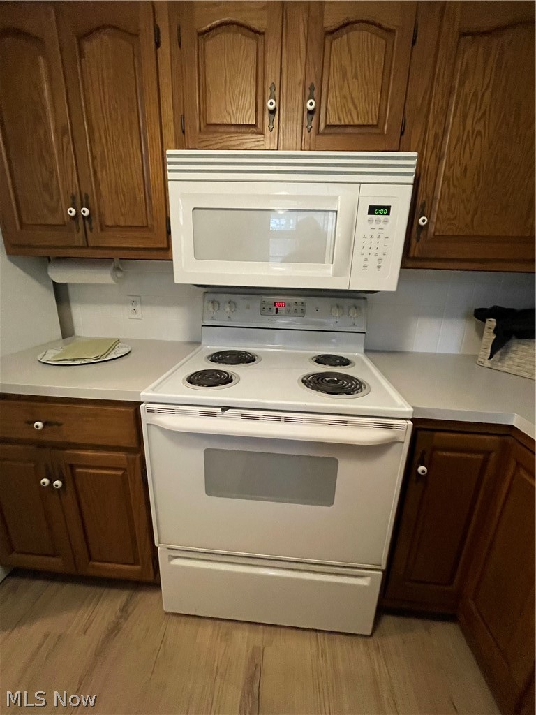 Kitchen with white appliances, 30 year waterproof LTV, and wood finish cabinetry