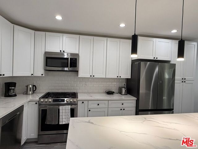 a kitchen with stainless steel appliances a refrigerator sink and microwave