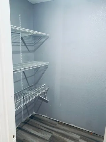 a view of a utility room with closet and wooden floor