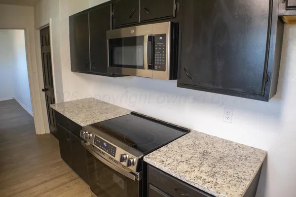 a view of a room with wooden floor and a ceiling fan
