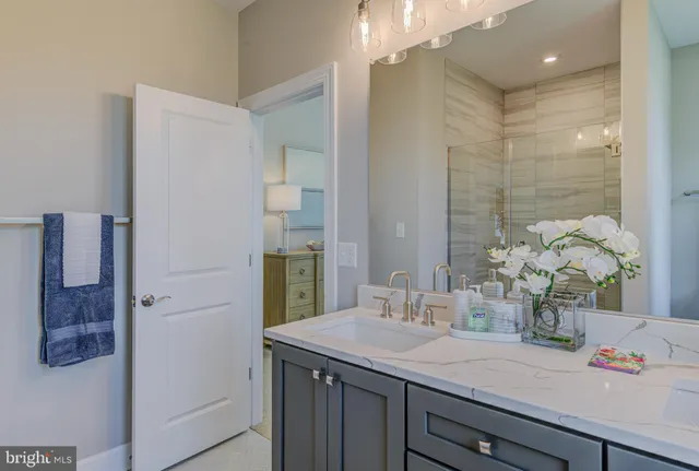 a bathroom with a granite countertop sink a shower and a mirror