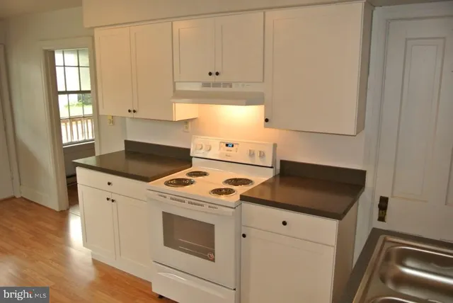 a kitchen with a stove and white cabinets