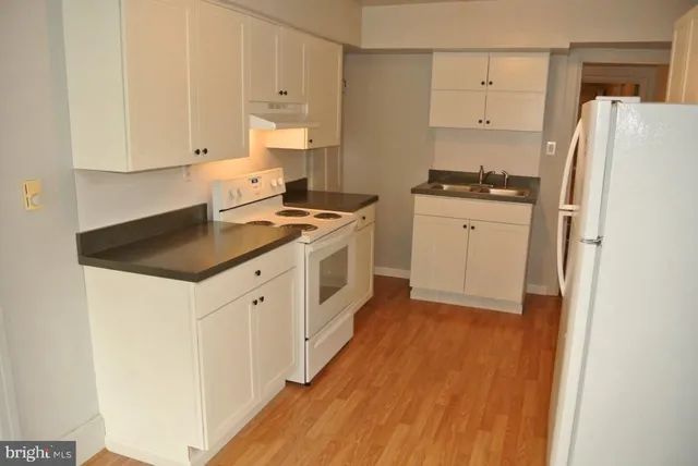 a kitchen with a refrigerator stove and white cabinets