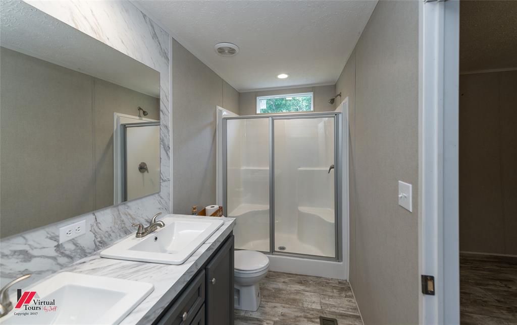 2470 Highway 792 Heflin, LA 71039 - Photo 16 of 25 a bathroom with a granite countertop sink a toilet and shower