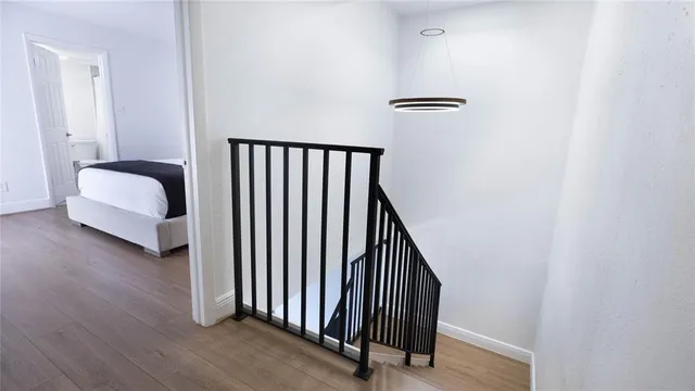 a view of a hallway with bedroom and wooden floor